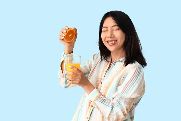 Gyönyörű Ázsiai Egy Pohár Gyümölcslé Narancs Kék Háttér — Stock Fotó