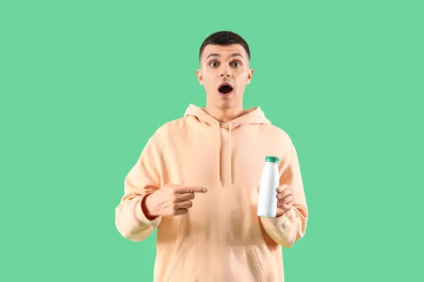 Shocked Young Man Pointing Bottle Tasty Yogurt Green Background — Stock Photo, Image
