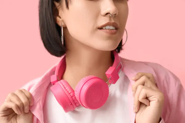 Κομψή Νεαρή Γυναίκα Σκουλαρίκι Στη Μύτη Και Ακουστικά Ροζ Φόντο — Φωτογραφία Αρχείου