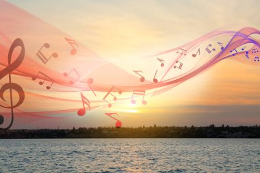 Gün batımında nehrin yanında uçan notalarla güzel gökyüzü manzarası