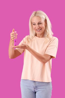 Mor arka planda anal tıpası olan olgun bir kadın.