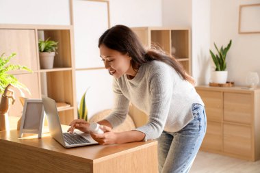 Genç Asyalı kadın evde hap tarifini kontrol ediyor.