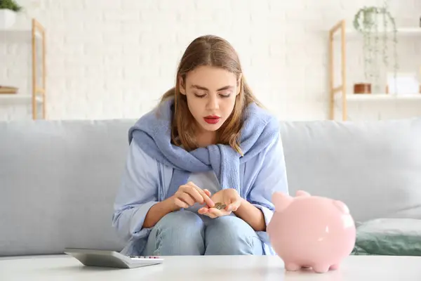 Young woman counting coins at home. Price rise concept