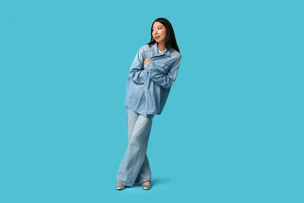 青い背景にスタイリッシュなデニムの服で美しい若いアジアの女性 — ストック写真