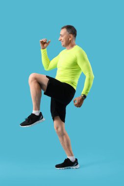 Mavi arka planda spor yapan orta yaşlı bir adamın portresi