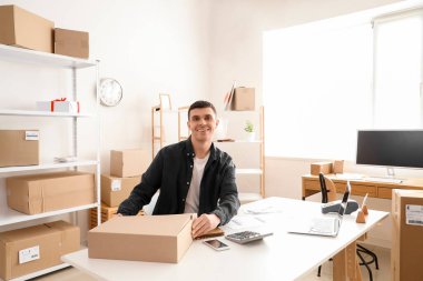 Depoda paket kutusu olan bir erkek çevrimiçi mağaza satıcısı.