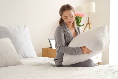 Yatak odasında pijama giymiş güzel bir genç kadın.