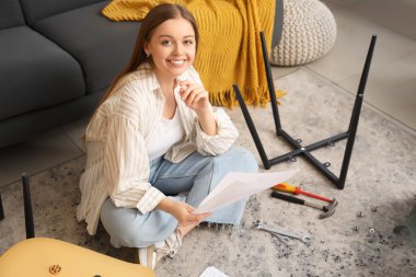 Evinde mobilya montajı yapan genç ve güzel bir kadın.