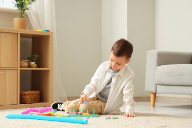 Evde otistik bozukluğu olan küçük bir çocuk oynuyor.