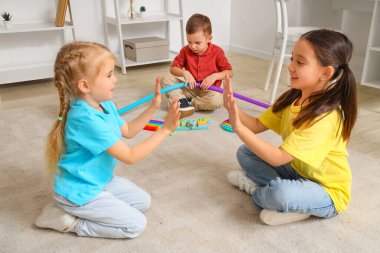 Otistik bozukluğu olan yalnız bir çocuk ve evde oynayan kızlar.