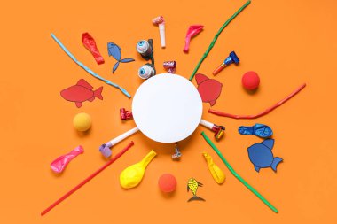 Kağıt balıklı boş kart, komik gözlükler ve turuncu arka planda parti dekoru. 1 Nisan şakası