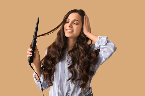 Beautiful Young Woman Curling Iron Beige Background — Stockfoto