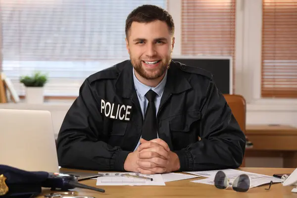 Male police officer sitting in office