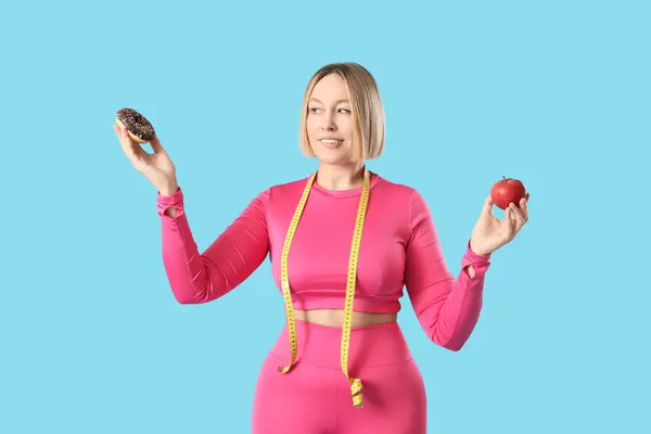 Pretty Young Woman Sportswear Tempted Eat Donut Instead Apple Blue — Stock Photo, Image