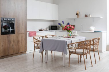 Paskalya yumurtaları, laleler ve yemek takımlarıyla dolu yemek masası.