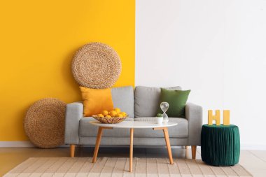 Güzel bir oturma odası, rahat bir kanepe, masa, halı ve puf.