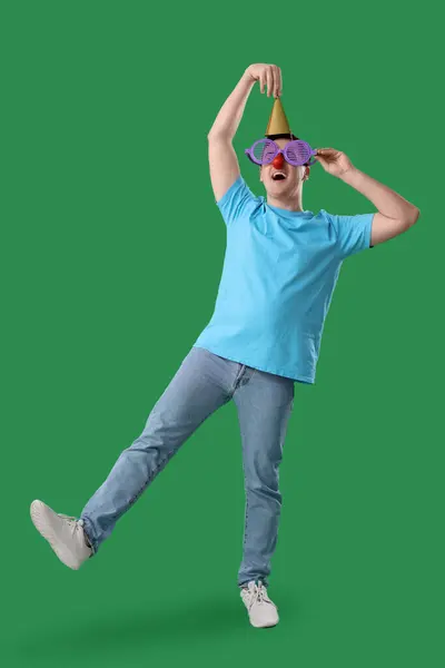 Junger Mann Mit Partyhut Und Lustiger Verkleidung Auf Grünem Hintergrund — Stockfoto