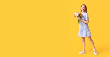 Sarı arka planda bir buket güzel lalesi olan genç ve güzel bir kadın.