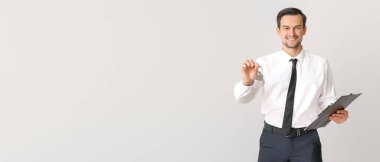 Açık arkaplanda anahtarı olan ve metin için yeri olan erkek emlakçı