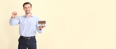 Açık arkaplan üzerinde anahtar ve model ev sahibi erkek emlakçı.