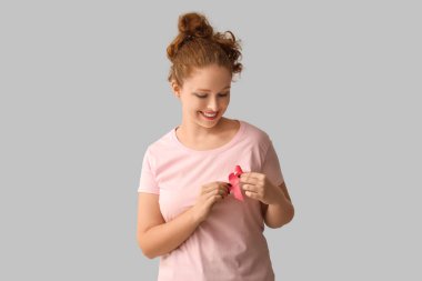 Pembe kurdeleli genç bir kadın. Göğüs kanseri farkındalığı konsepti