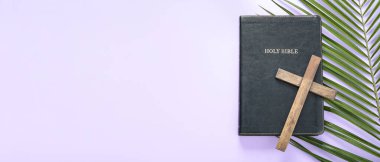 Ahşap haç, kutsal İncil ve eflatun arkaplanlı palmiye yaprağı. İyi Cuma konsepti