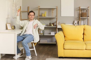 Genç adam eve kağıt uçak fırlatıyor.