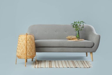 Gri arka planda kanepe ve hasır fener olan modern oturma odası.