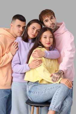 Hafif arka planda sarılan bir grup şık genç.