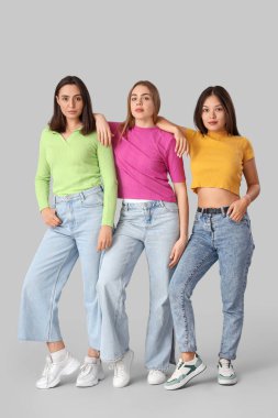 Hafif arka planda şık kotlu genç kadınlar