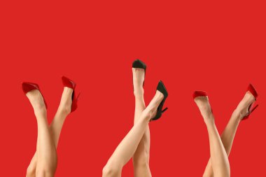 Kırmızı arka planda farklı ayakkabılar giyen kadın bacakları.