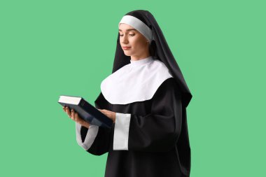 Yeşil arka planda İncil 'i olan rahibenin portresi.
