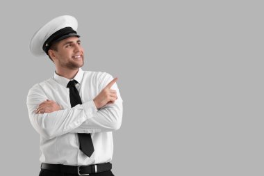 Erkek pilot arka plandaki bir şeyi işaret ediyor.