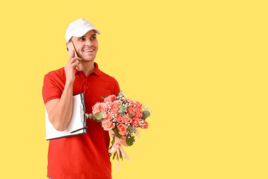 Bir buket çiçekli erkek kurye ve sarı arka planda cep telefonuyla konuşan bir pano.