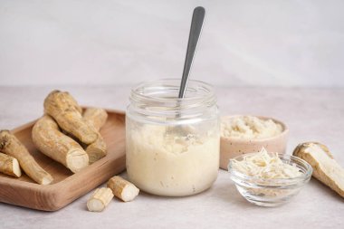 Kâselerde yabanturpu sosu ve beyaz arka planda yer turpu ile kavanozu.