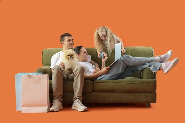Счастливая Семья Покупки Онлайн Диване Оранжевом Фоне — стоковое фото