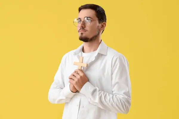 Young Man Wooden Cross Praying Yellow Background — Stock Photo, Image