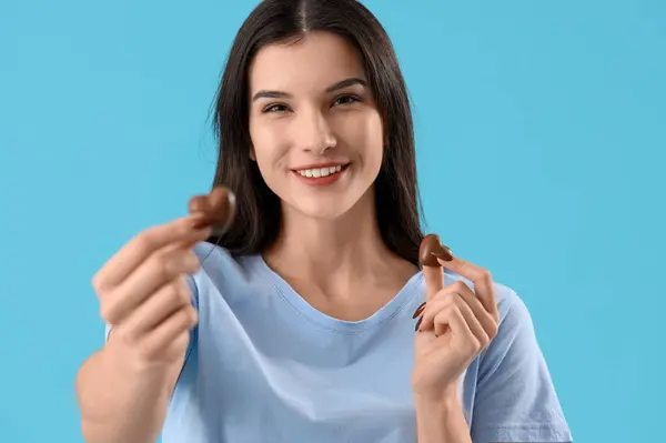 Junge Frau Mit Herzförmigen Schokoladenbonbons Auf Blauem Hintergrund Nahaufnahme — Stockfoto