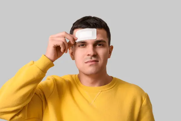 脳脳脳震盪と軽い背景の医療パッチを持つ若い男 クローズアップ — ストック写真