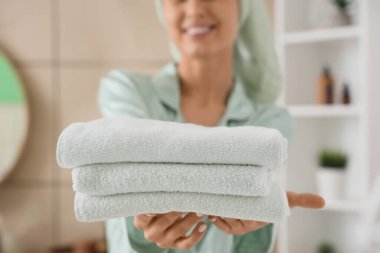 Banyodaki duştan sonra temiz havlularla güzel bir kadın, yakın plan.