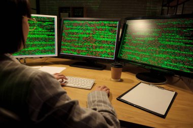 Geceleri bilgisayarla çalışan kadın programcı.