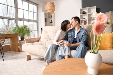 Genç çift evdeki kanepede burunlarına dokunuyor.