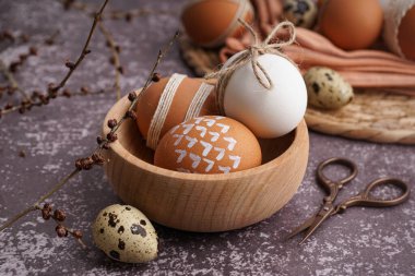 Süslü Paskalya yumurtalarının olduğu ahşap bir kase.