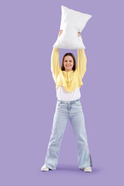 Leylak arka planında yastıkla savaşan genç kadın