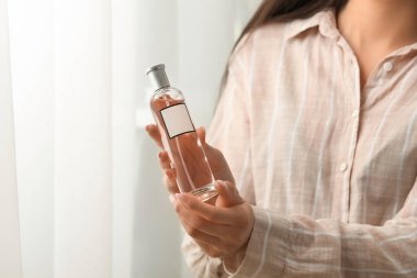 Genç kadın evde parfüm şişe