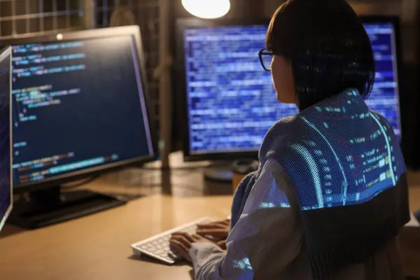 Stock image Young female programmer with projection of code working in office at night