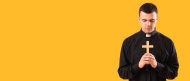 Sarı arka planda dua eden genç bir rahip ve metin için yer var. 