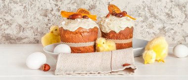 Beyaz ahşap masada tavukların ve yumurtaların olduğu Paskalya pastaları. 