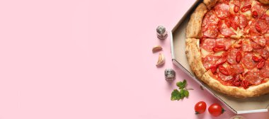 Karton kutuda nefis biberli pizza ve pembe arka planda metinler için yer olan malzemeler. 