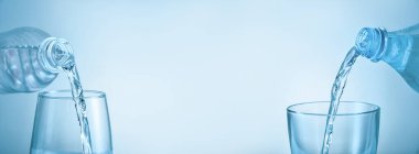Açık mavi arka planda bardaklara taze su dökülüyor.